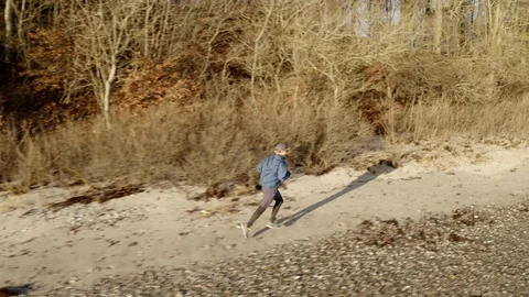 Young man jogging on beach in Denmark Stock Footage 103214491