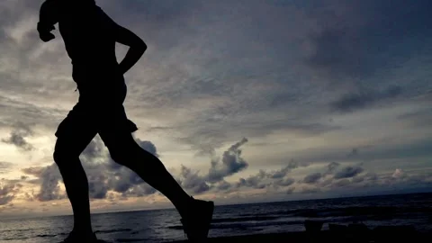 Young man jogging on the beach during sunset, super slow motion, shot at 240fps Stock Footage 149183683