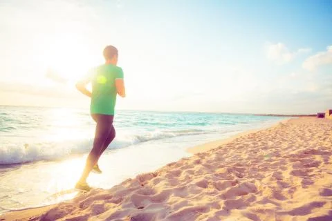 Young Man Jogging On The Beach Stockfoto's
