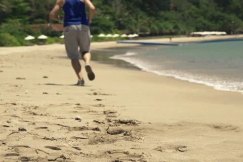 Young man jogging on the beach, shot at 240fps NTSC Video stock 55098096