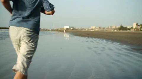 Young man jogging on the beach, slow motion HD Stock Footage 10894415