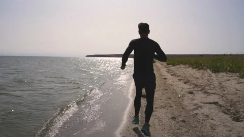 The young man is jogging on the beach. slow motion Stock-Footage 145750798