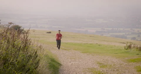 Young man jogging in meadow Stock Footage 59899999