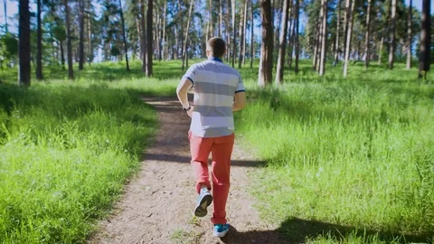 Young man jogging in the park. He accelerating and running on the limits. Stock Footage