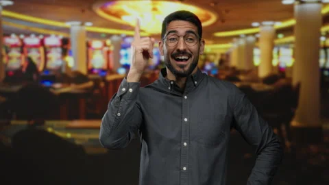 Young man with joyful expression making idea gesture in a lively casino bac.. Stock Footage 306814771