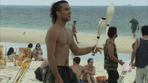 Young man juggling on beach Stock Footage 52377653