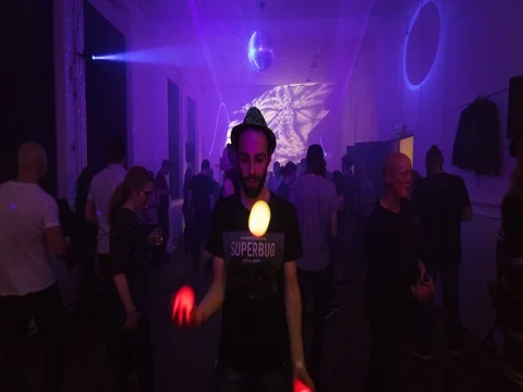 Young man juggling with luminous balls at a dance party Stock Footage 77187093