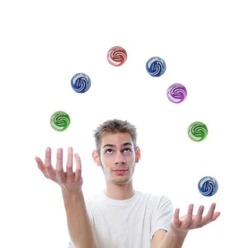 Young man juggling several multicolored balls at once, this concept also appl Stock Photos