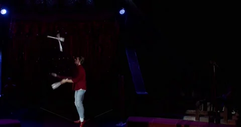 Young man is juggling on stage, circus performance, profile shot, 4k Stock Footage 147486063