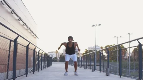 Young man jumping and posing with arms folded in air Stock Footage 132070407