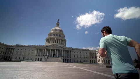 Young man jumping for joy in front of the US Capitol in slow motion. Stock Footage 128717747
