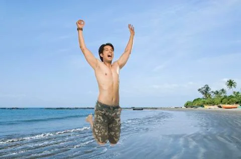 Young man jumping with joy Fotos Stock