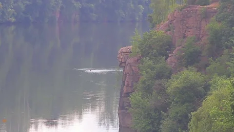 Young man jumping into lake Stock Footage 72792587