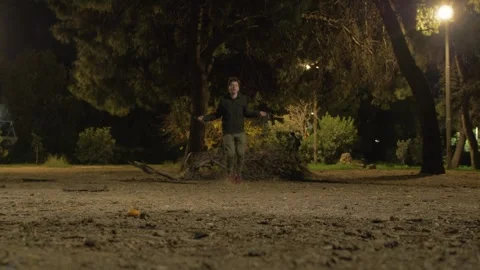 Young man jumping rope skipping in park at night Stock Footage 262035966