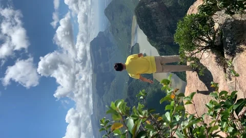 Young man jumping with scenic view of Blyde river canyon Vídeo Stock 151865935