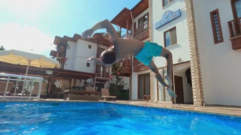 Young man jumping in swimming pool, having fun on summer vacation. Stock Footage 144385019