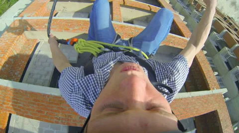 A young man jumping with unfinished floor skyscraper Stock Footage 38187776