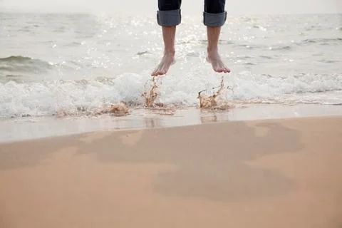 Young Man Jumping in the Waves Stock Photos