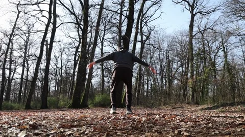 Young man is jumping in the woods. Stockbeeldmateriaal 228947742