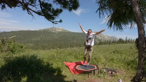 A young man jumps on a trampoline Video stock 129600402