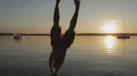 Young Man jumps into Water while sun set 스톡 동영상 48606858