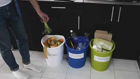 Young man in kitchen during quarantine. Video of three buckets for plastic Stock Footage 128936147