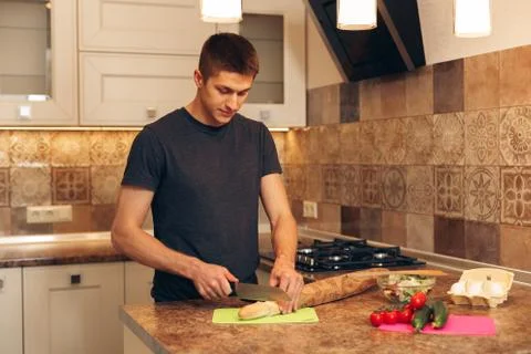 Young man in the kitchen prepares breakfast Foto stock
