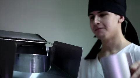 Young man kitchen worker in black bandana putting tiny dry corn seeds into autom Stock Footage 137541501