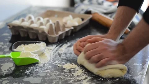 The young man is kneading dough on the table Stock Footage 133280942