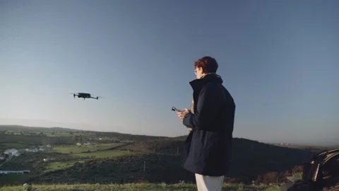 Young man landing a drone in from of him with security. Stock Footage 240397990