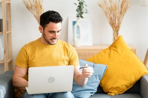 Young man with laptop checking his bank statement. Stock Photos
