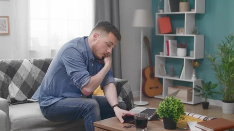 Young man with laptop computer calling on smartphone at home Stock-Footage 106808975