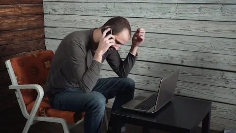 A young man with laptop receiving negative news, upset and surprised Stock Footage 82443822