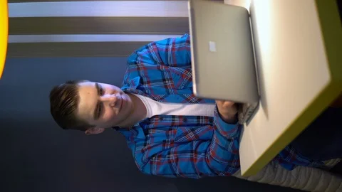 A young man with a laptop sits at a table. A man is sitting at cafe at the table Stock Footage 126504118