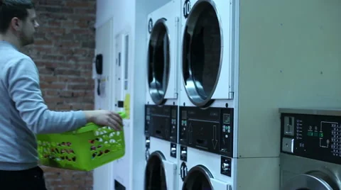 Young man in the laundry Stock Footage 64954190