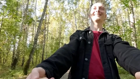 Young man leading girlfriend through forest holding hands Stock Footage 314031837