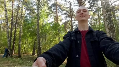 Young man leading viewer through forest holding hands Stock Footage 314631725