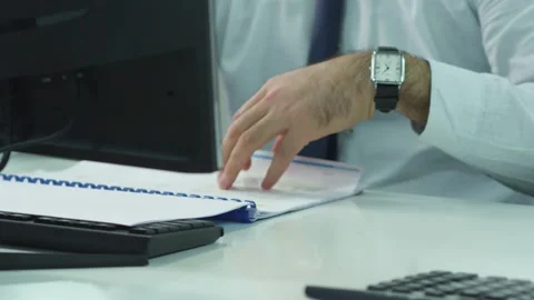 A young man leafing through a catalog in the office Stock Footage 160466530