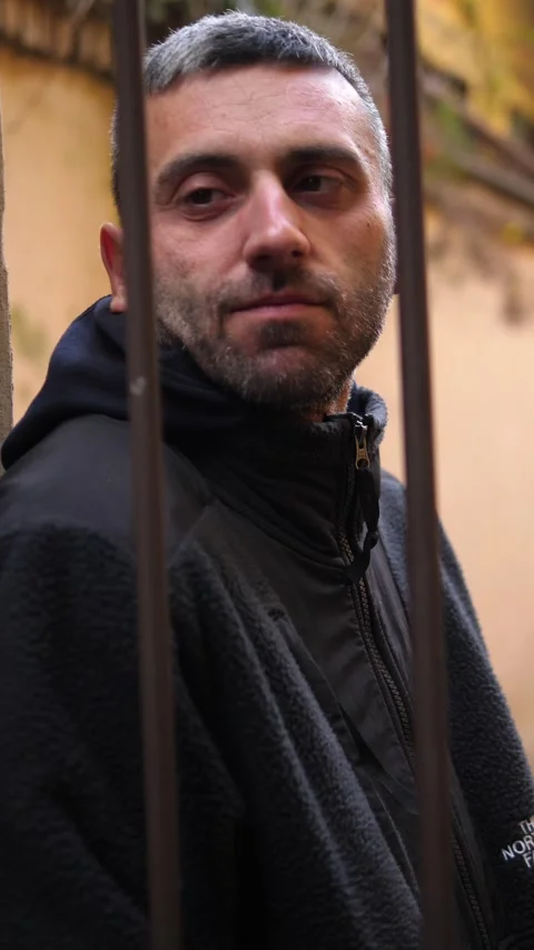 Young man leaning on gate looking thoughtful and reflective Stock Footage 332417927