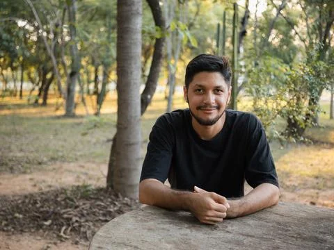 Young man leaning on stone table in natural park Stock Photos