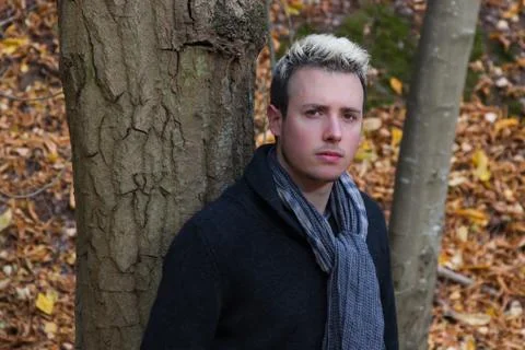Young man leaning on a tree Foto stock