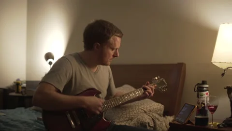 Young Man Learning Guitar Bedroom Evening 2 Stock Footage 149371633