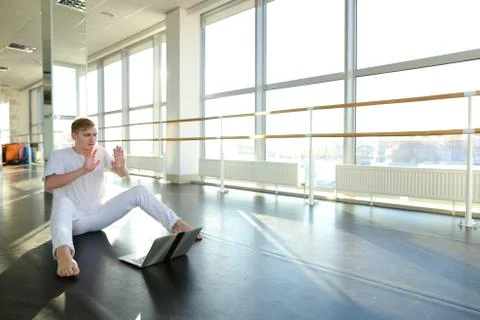 Young man learning new dancing technique with laptop tutorial. Fotos Stock