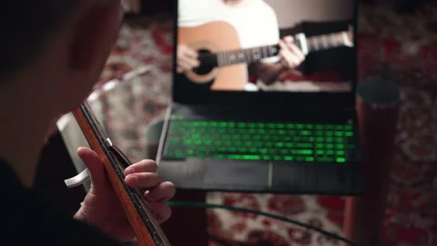 Young man is learning to play the acoustic guitar. remote online lesson. Stock Footage 207783585