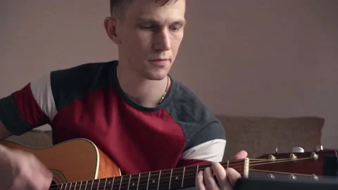 Young man is learn.ing to play the acoustic guitar. online learning. Video stock 207783883