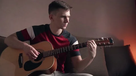 Young man is learn.ing to play the acoustic guitar. online learning. Stock Footage 209308307