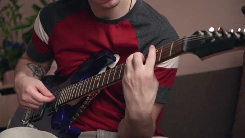 Young man learning to play electric guitar online using laptop. close-up Stock Footage 212612105
