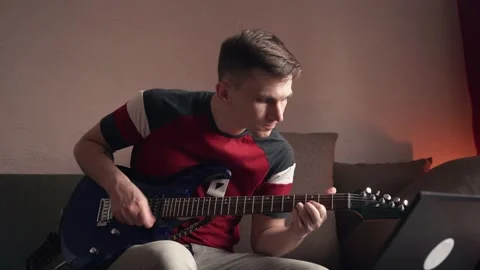 Young man learning to play electric guitar online at home. quarantine Stock Footage 212612465