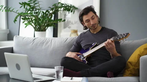 Young man learning to play guitar Stock Footage 149246590