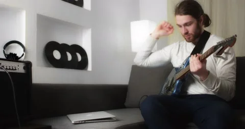 Young man is learning to play the guitar online. Stock Footage 169936734